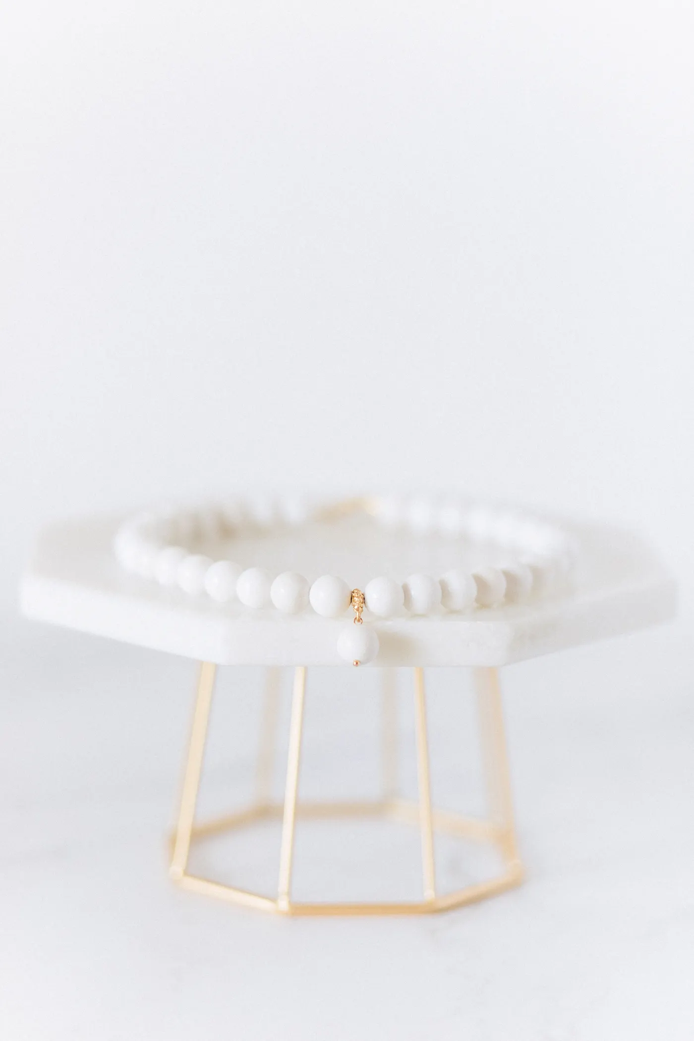 Elegant pearl and gold jewellery arranged on a soft cream surface